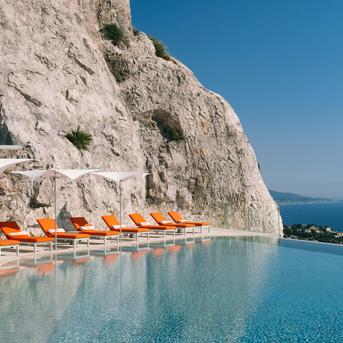 Swimming Pool at The Maybourne Riviera - Sunbeds next to the pool with view onto the sea