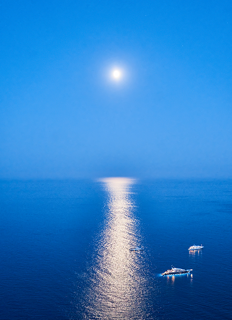 Vue de deux bateaux sur la mer avec le soleil brillant au-dessus.