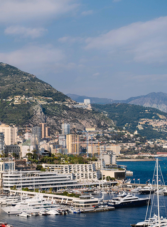 View of Monaco harbour with boats, yachts and superyachts, and The Maybourne Riviera in the background.