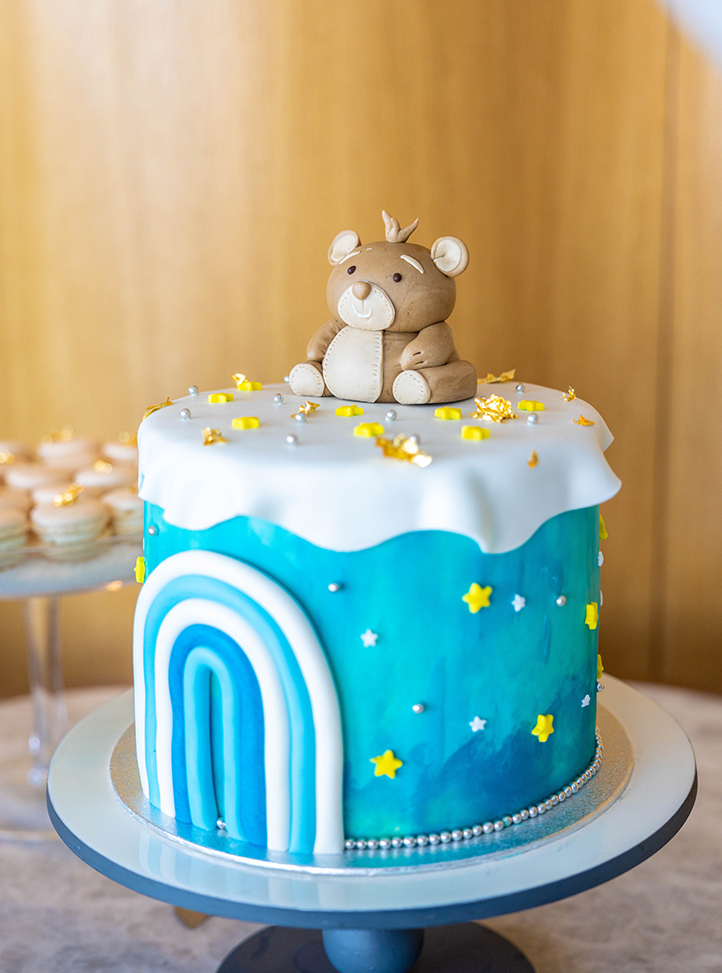 Un gateau recouvert de glaçage bleu et avec un ours sur le dessus.